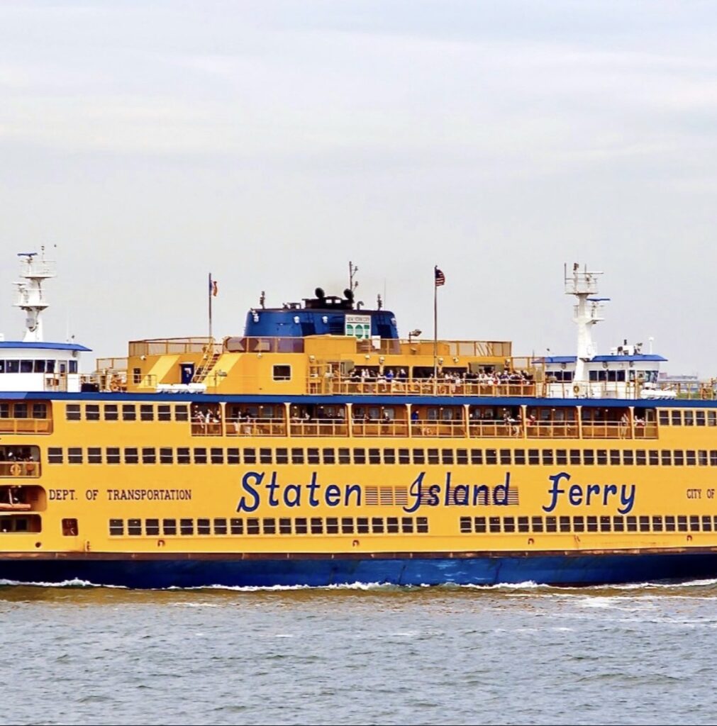 A bright orange Staten Island Ferry traveling across the water.